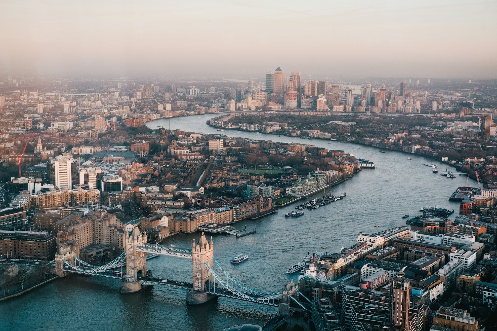Tower Bridge and the River Thames looking east towards Canary Wharf, seen from above at dusk