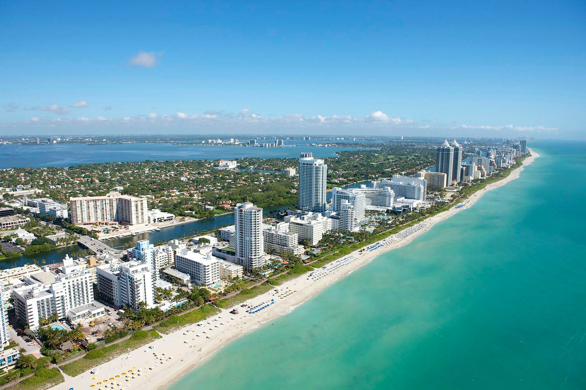 Aerial view of Miami Beach, with its high-rise hotels, the beach and Biscayne Bay behind
